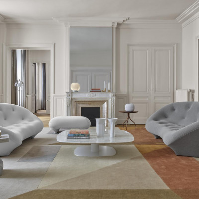 Un séjour avec du parquet, un radiateur, un tapis tissé à plat VINDERÖD, un canapé marron et un lampadaire SIMRISHAMN.