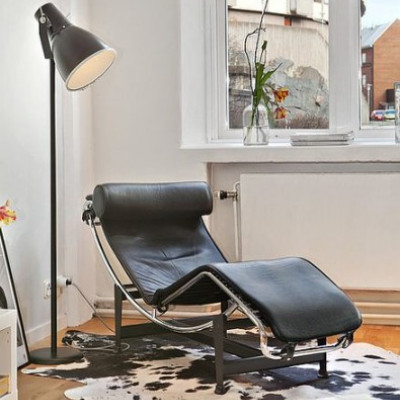 Un séjour avec du parquet, un radiateur, un tapis tissé à plat VINDERÖD, un canapé marron et un lampadaire SIMRISHAMN.