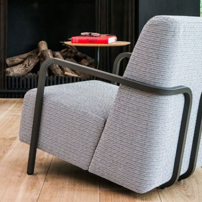 Un séjour avec du parquet, un radiateur, un tapis tissé à plat VINDERÖD, un canapé marron et un lampadaire SIMRISHAMN.